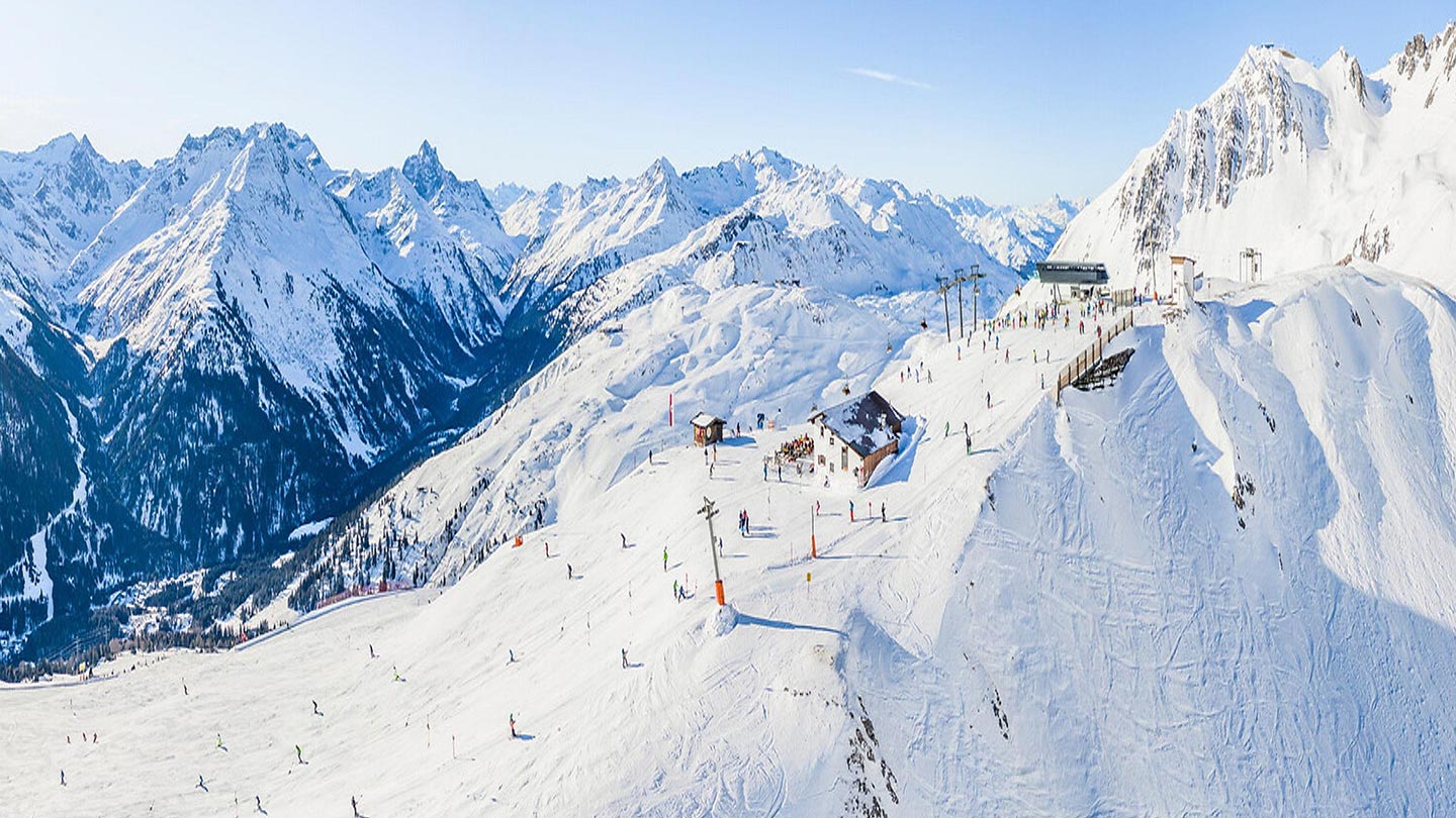 St. Anton am Arlberg i Österrike med snöiga berg och skidåkare.