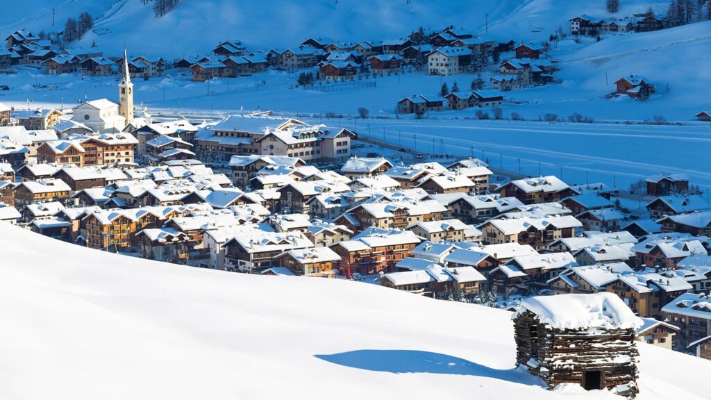 En snöklädd by i Livigno, Lombardiet, belyst av solen efter snöfall.