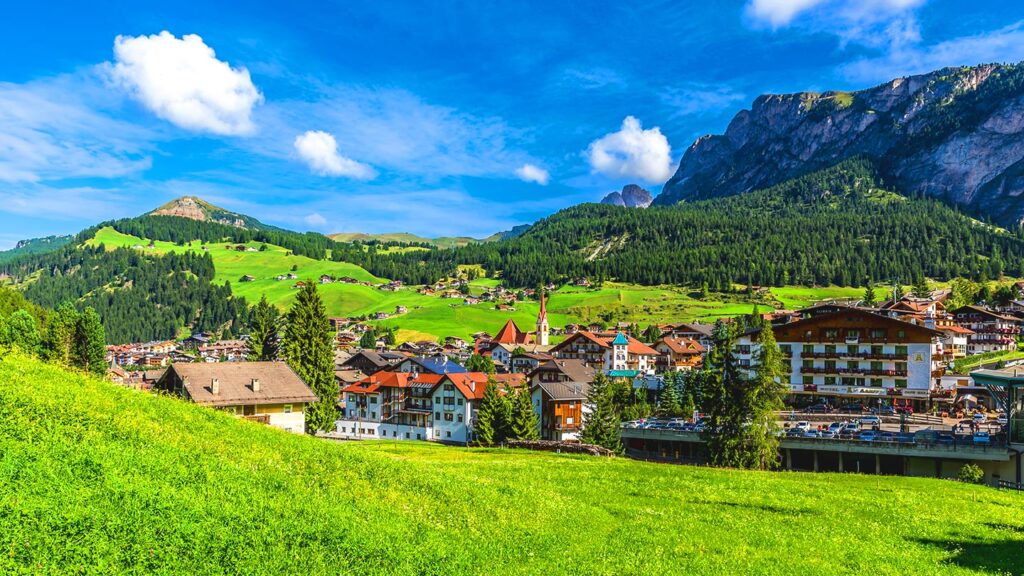 Val Gardena i Dolomiterna, vacker natur med berg och charmiga byggnader.