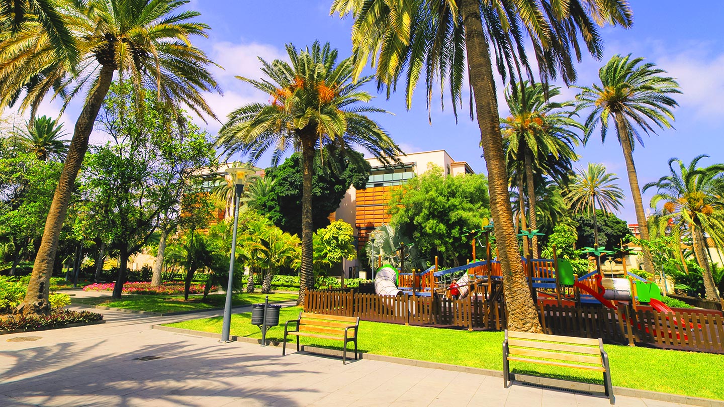 En vacker park i Las Palmas med palmer och lekplats i Gran Canaria.