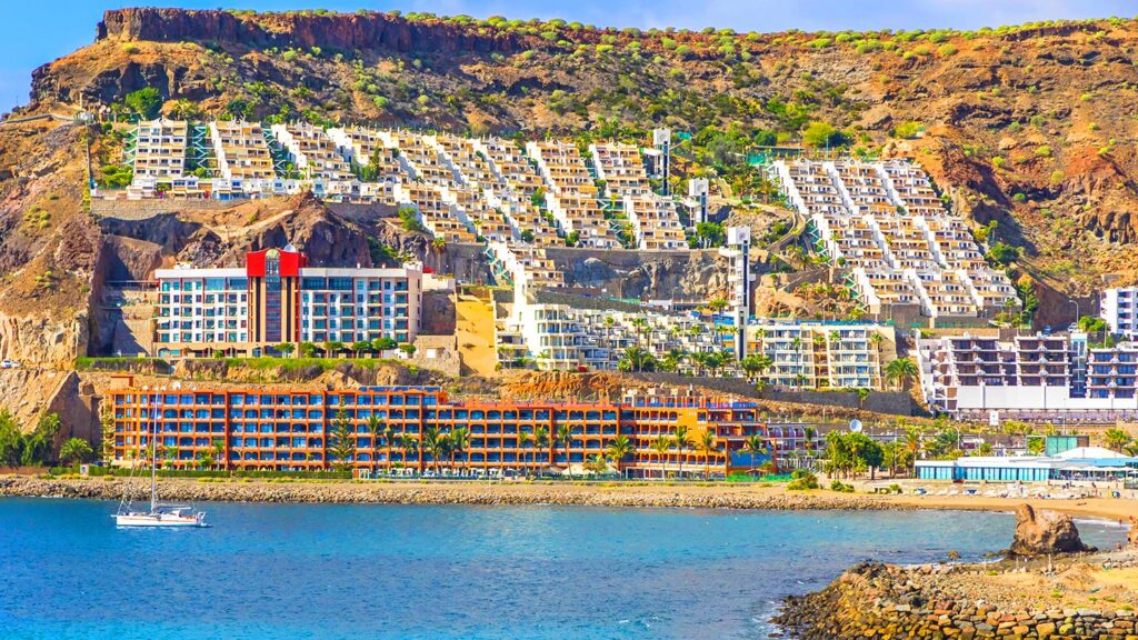 Bilden visar Playa del Cura med klippstrand och semesterorter i Puerto Rico, Gran Canaria.