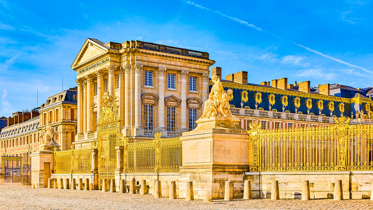 En solig dag vid Versailles slott med vacker arkitektur och gyllene detaljer.