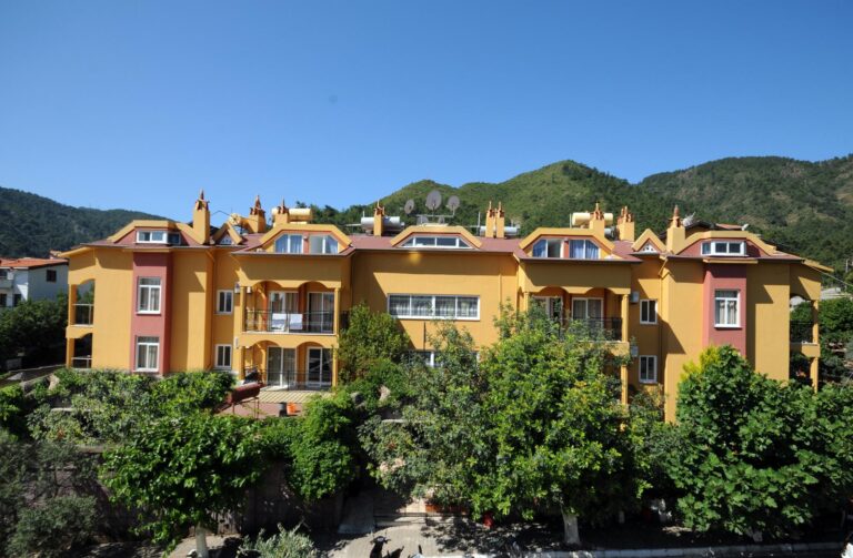 Kleopatra Apart i Marmaris med färgglad hotellfasad och grönska.