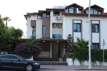 Parus Hotel i Kemer med hotellfasad och parkerade bilar.